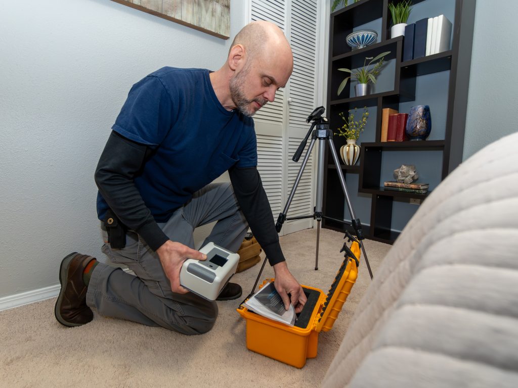 Radon technician setting up a radon test in a home